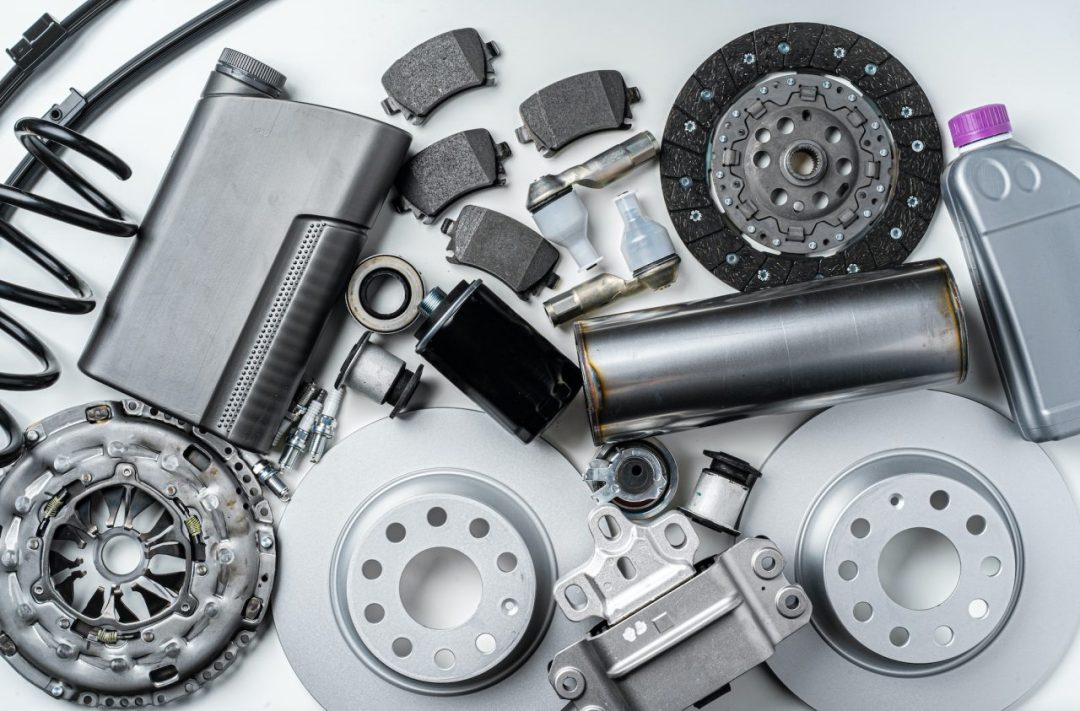 New metal auto parts on grey background